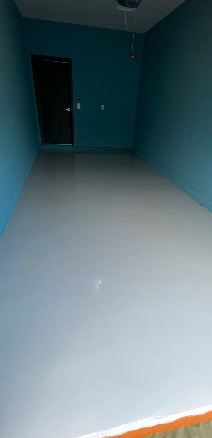 The same garage after the floor coating, a smooth light gray finish running the full length to the door